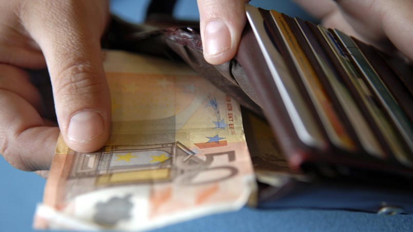 Close-up of a person's hand keeping euro banknotes in a wallet